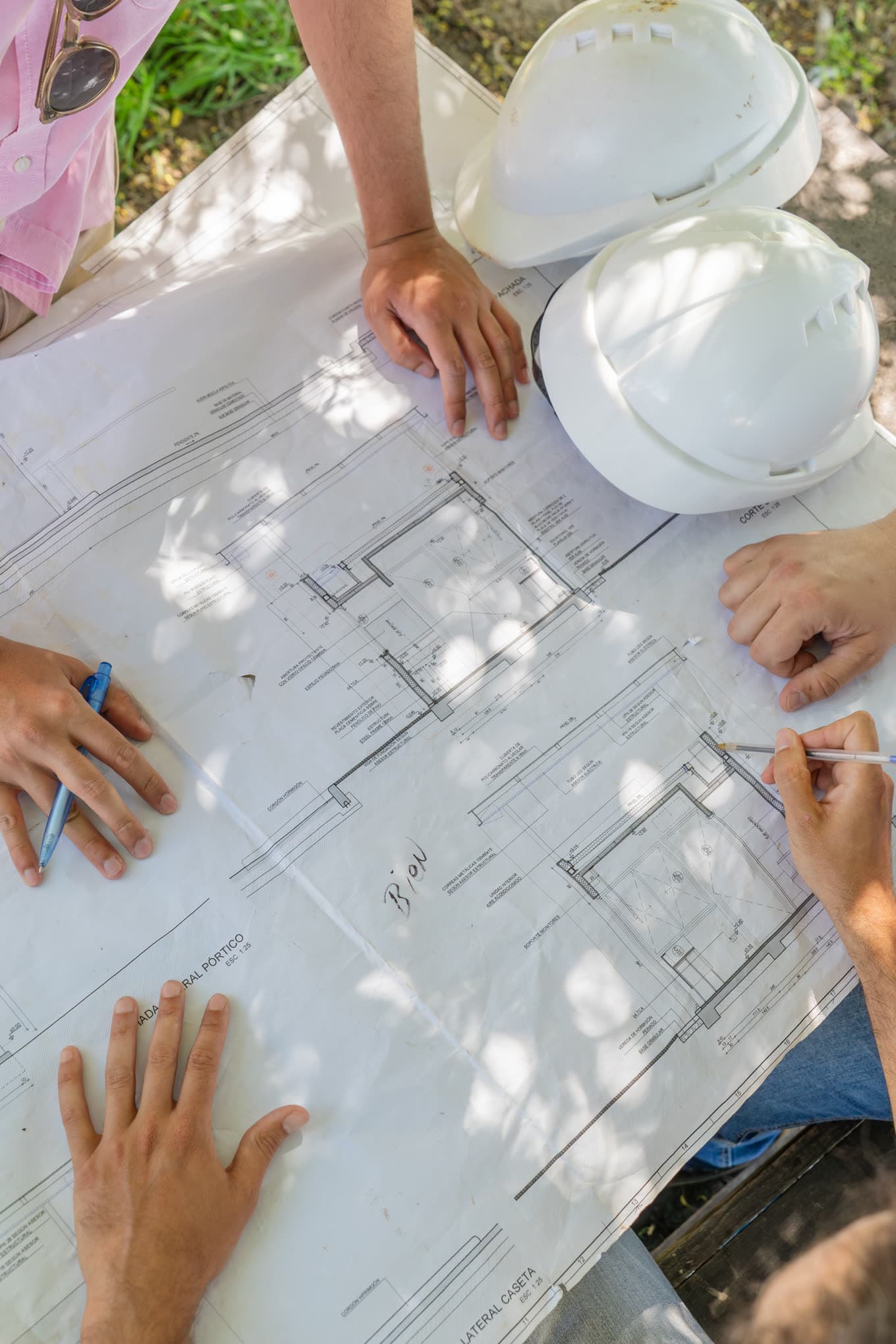 The three partners reviewing drawings on site