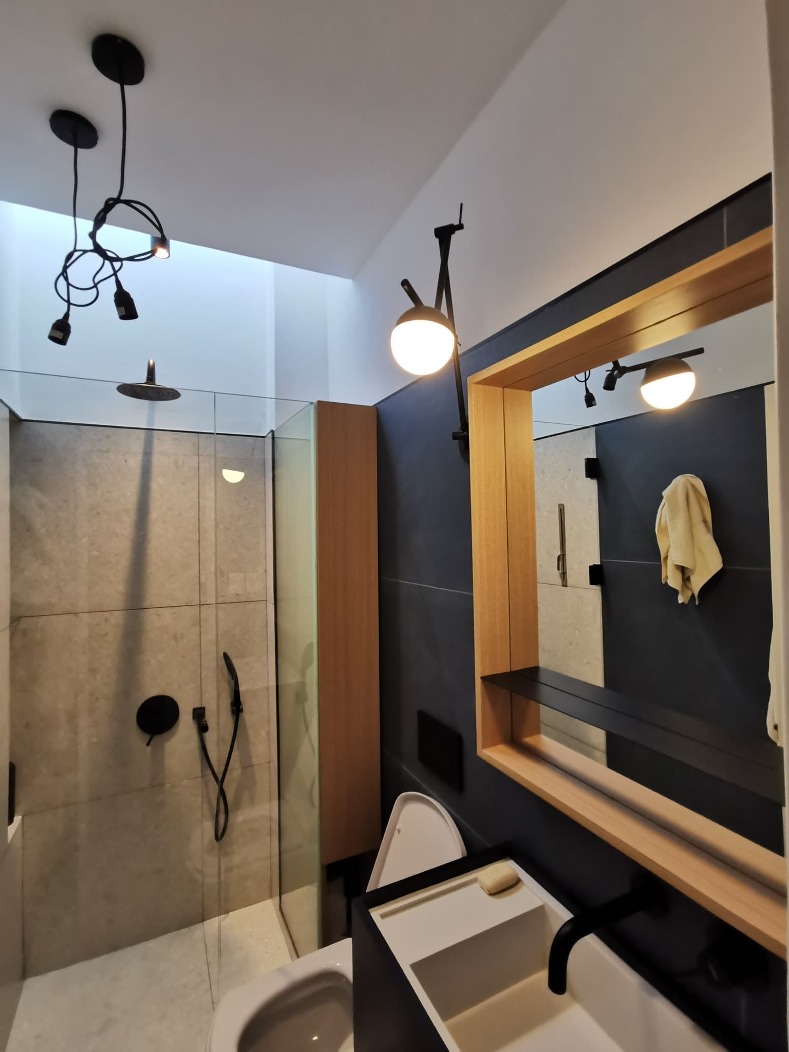 Amazonas — Bathroom with walk-in shower and wood-framed mirror
